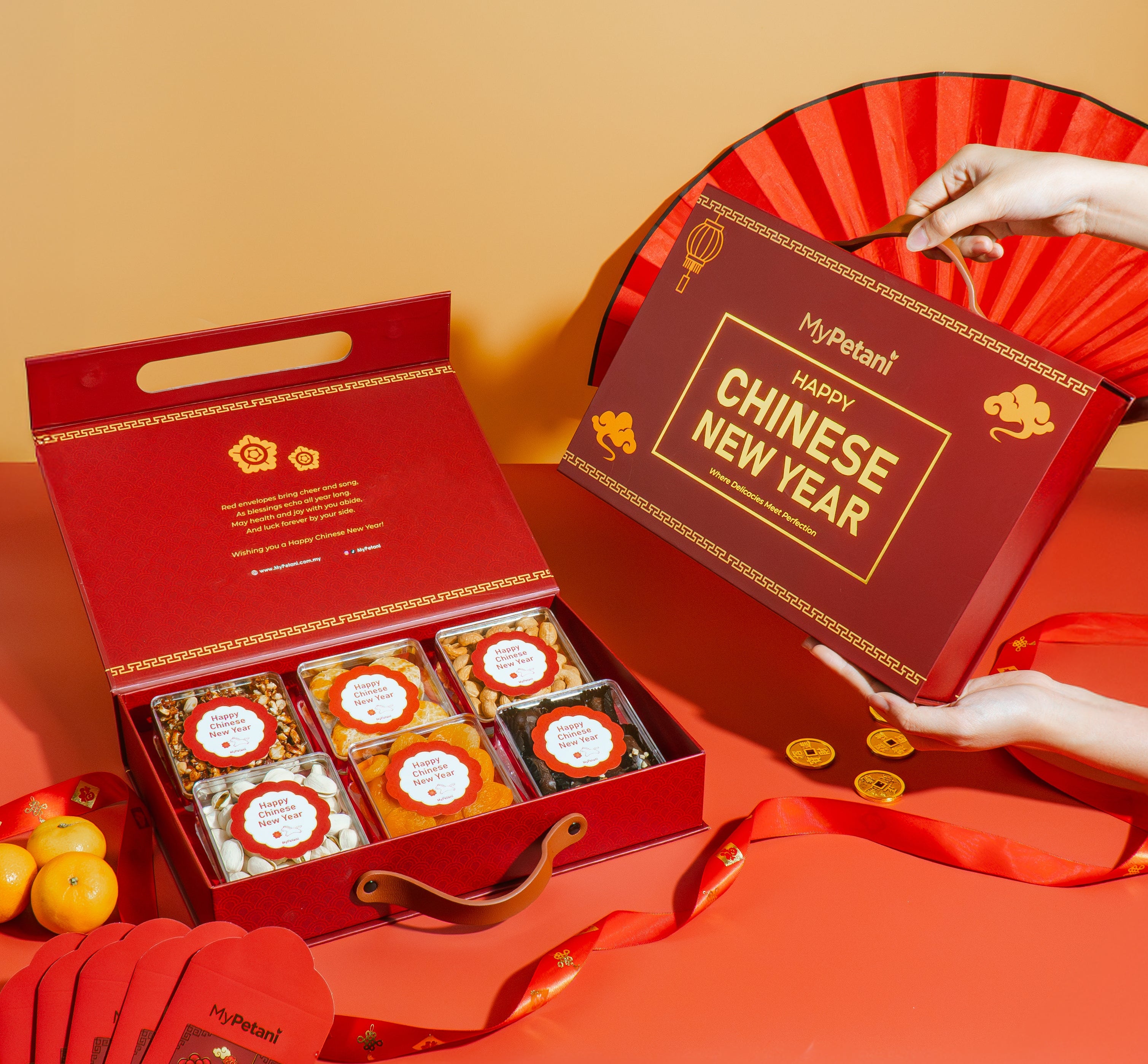 MyPetan Chinese New Year gift set with CNY snacks and cookies red boxes and fan on a red background
