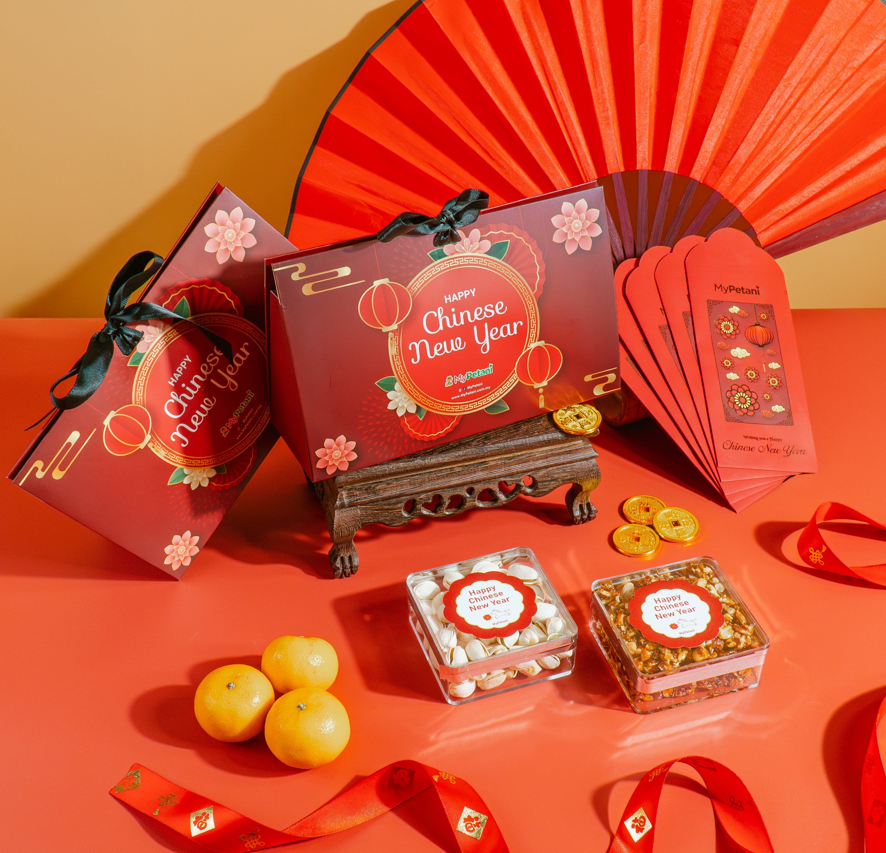 Chinese New Year-themed items including red envelopes, a fan, and small boxes on a red surface.