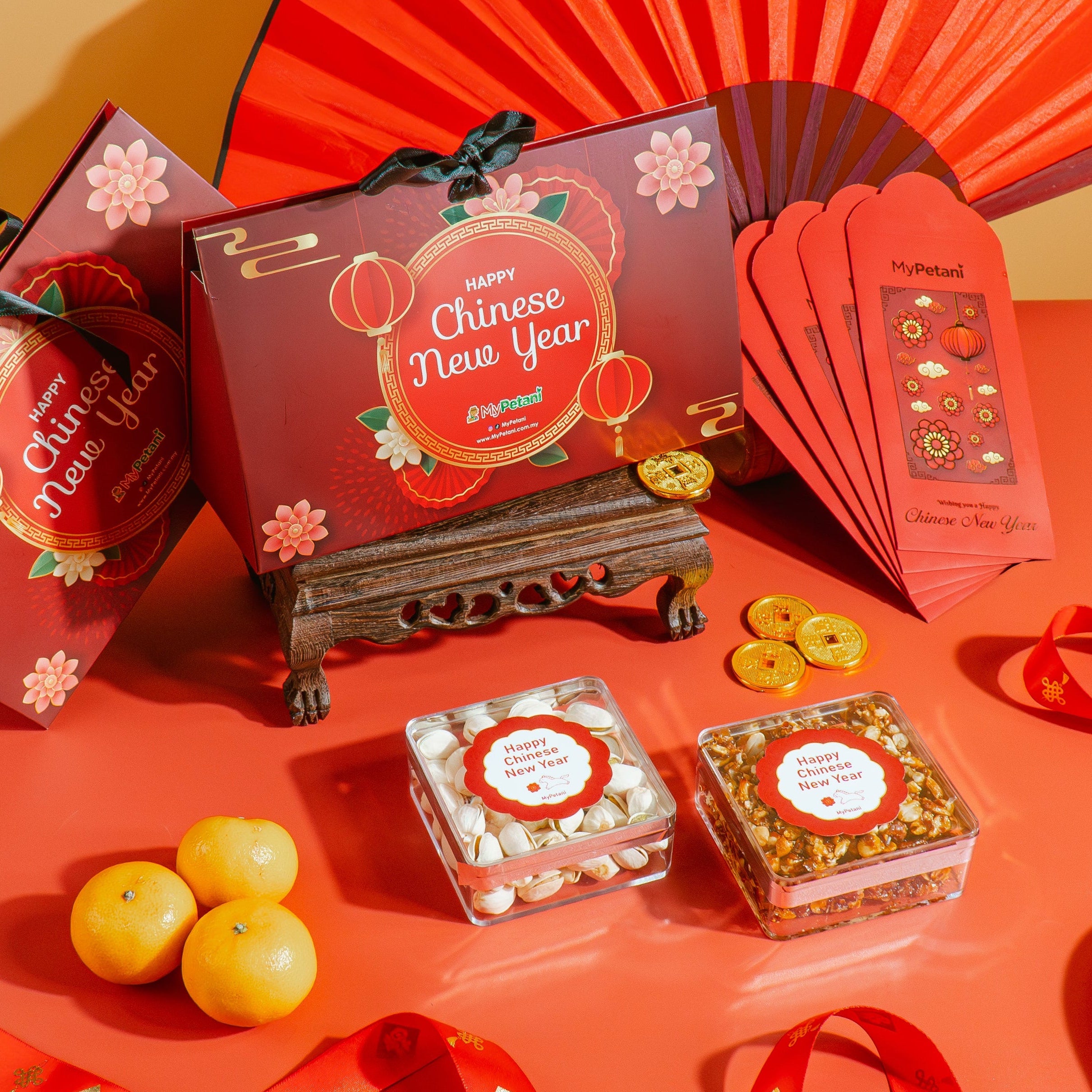 Chinese New Year-themed items including red envelopes, a fan, and small boxes on a red surface.