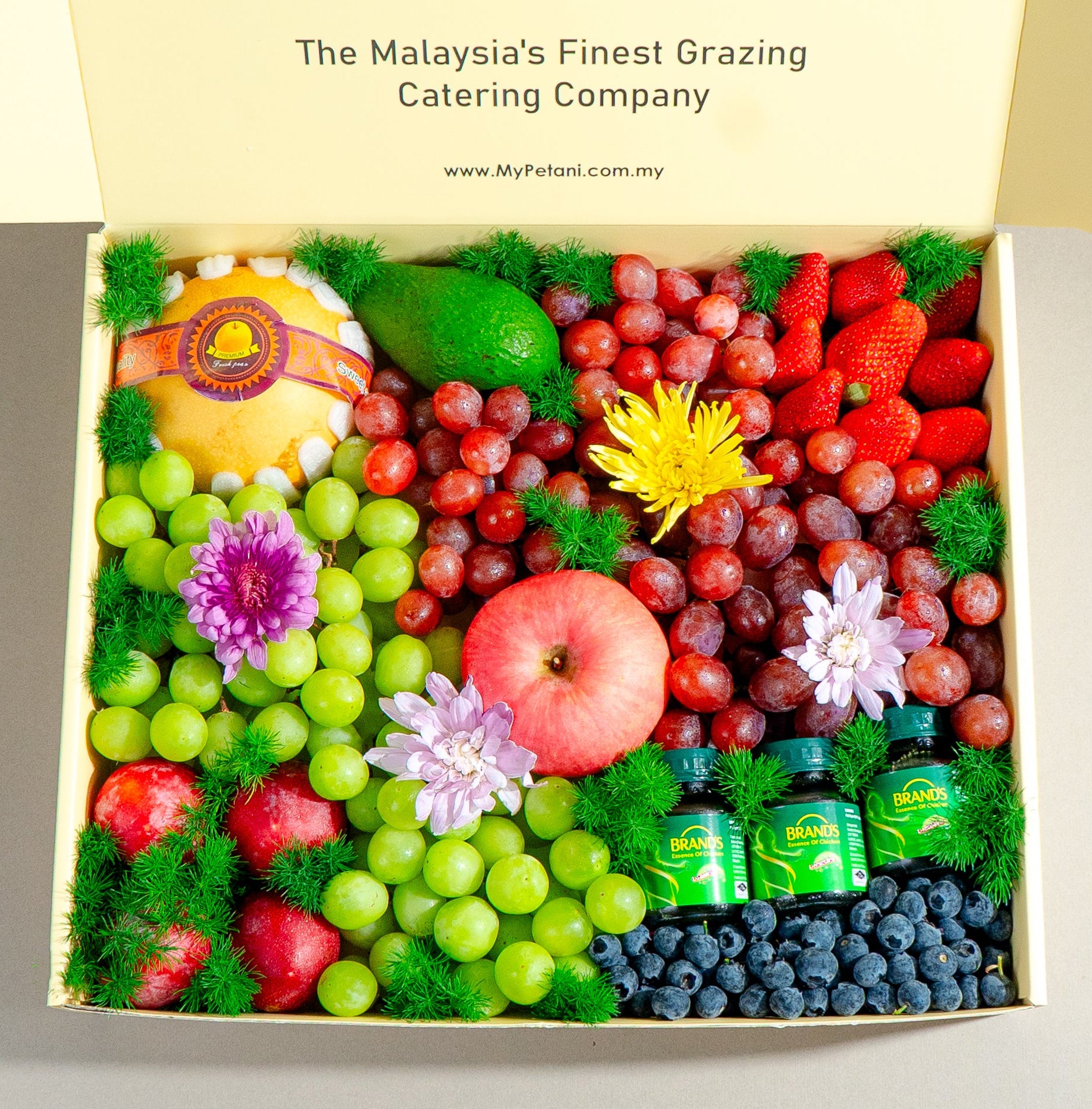 Fruit and chicken essence bottles box with a Malaysia's Finest Grazing Catering Company label.