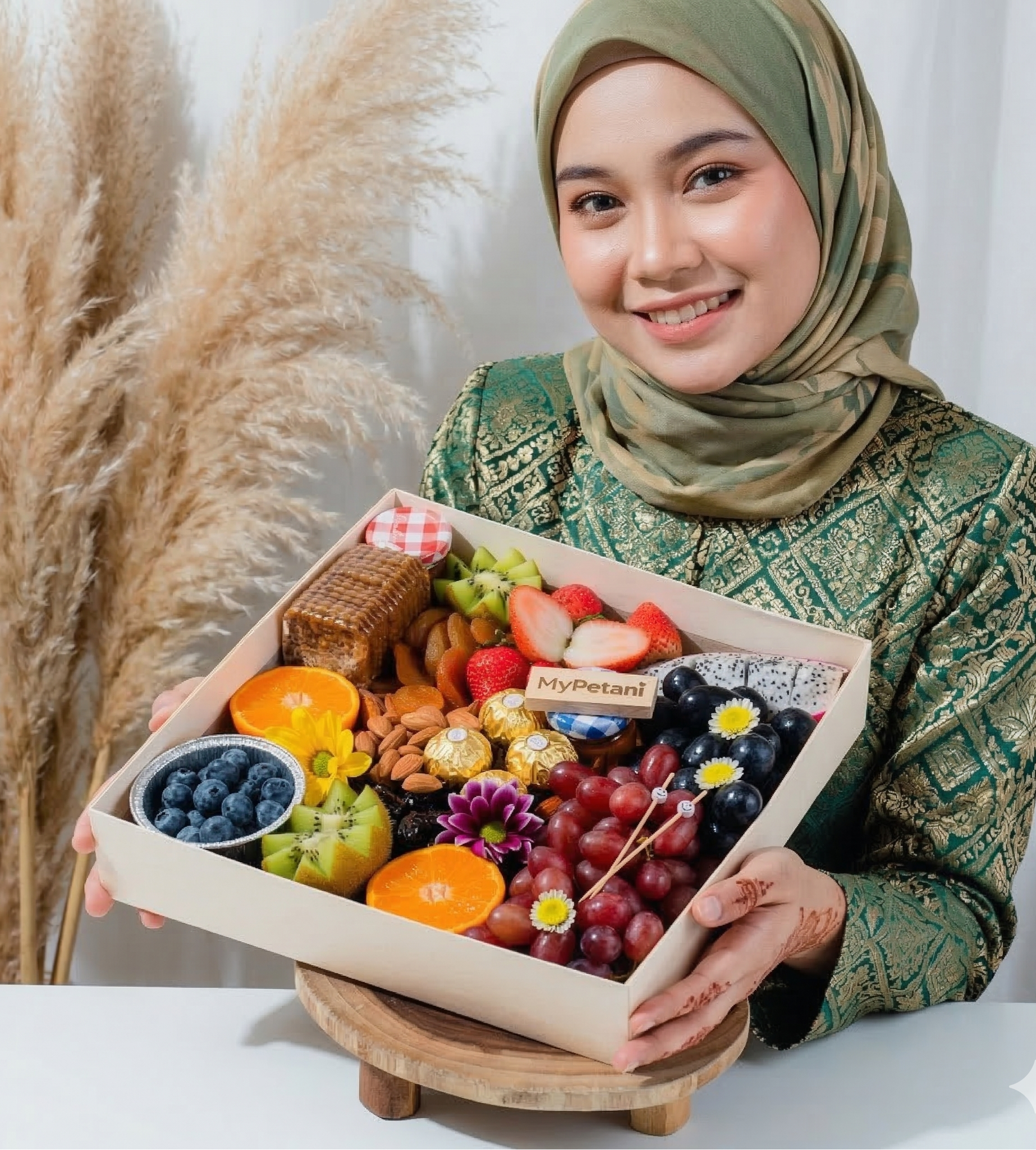 Woman holding a box of assorted fruits and snacks with a white background