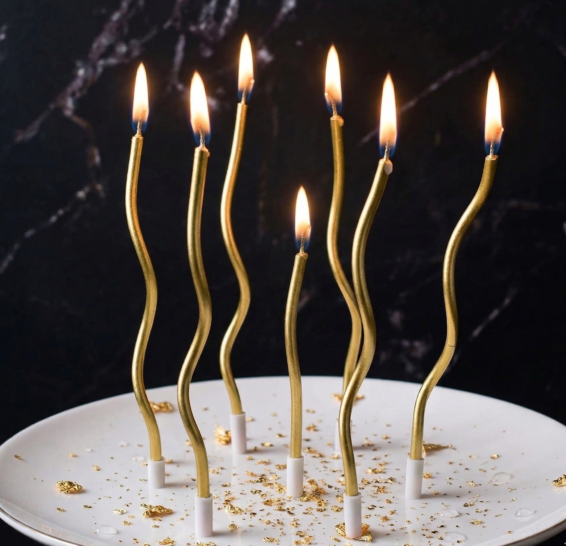 Gold candle sticks on a white plate with a dark marble background