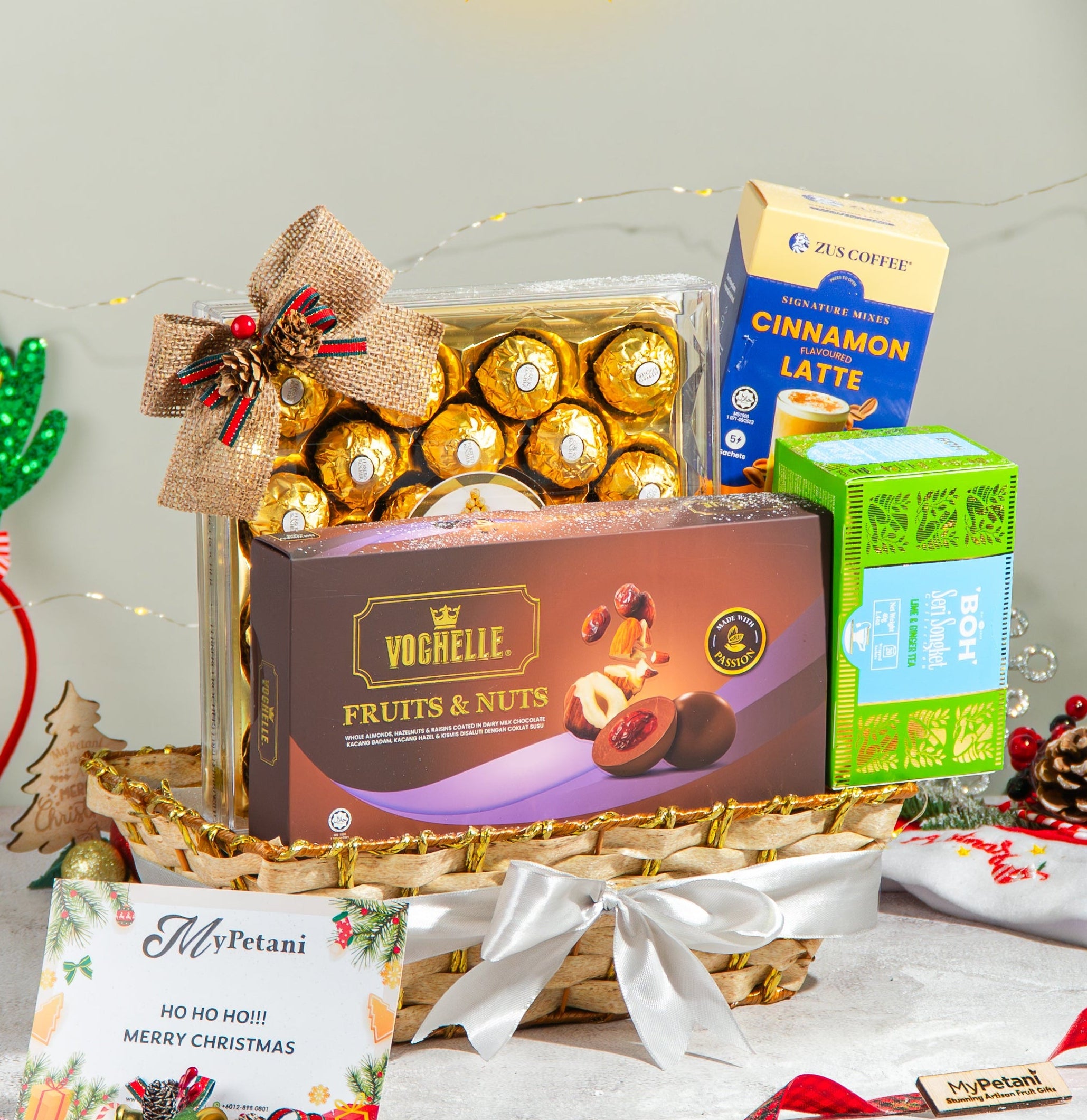 Gourmet gift basket with chocolate and coffee on a decorative tablecloth with Christmas decorations.
