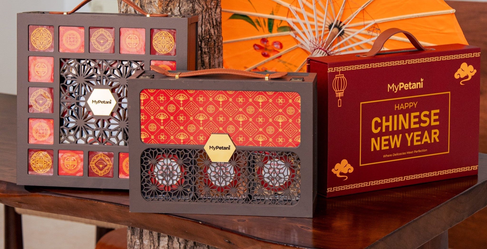Decorative boxes with a Chinese New Year theme on a wooden table.
