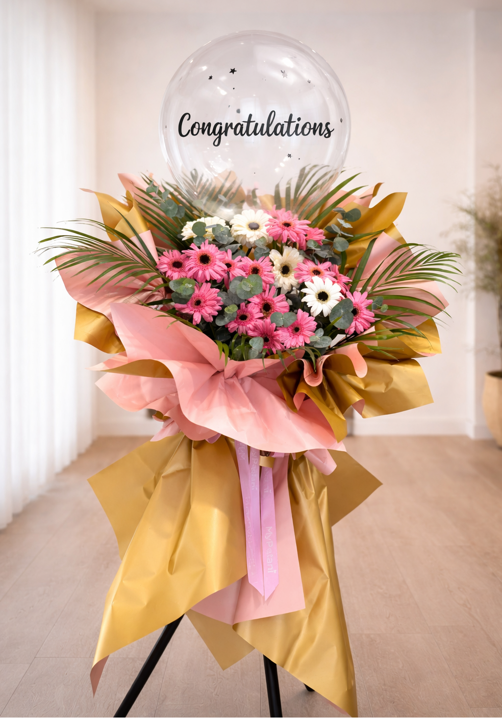 Bouquet of flowers with a 'Congratulations' balloon in a room.