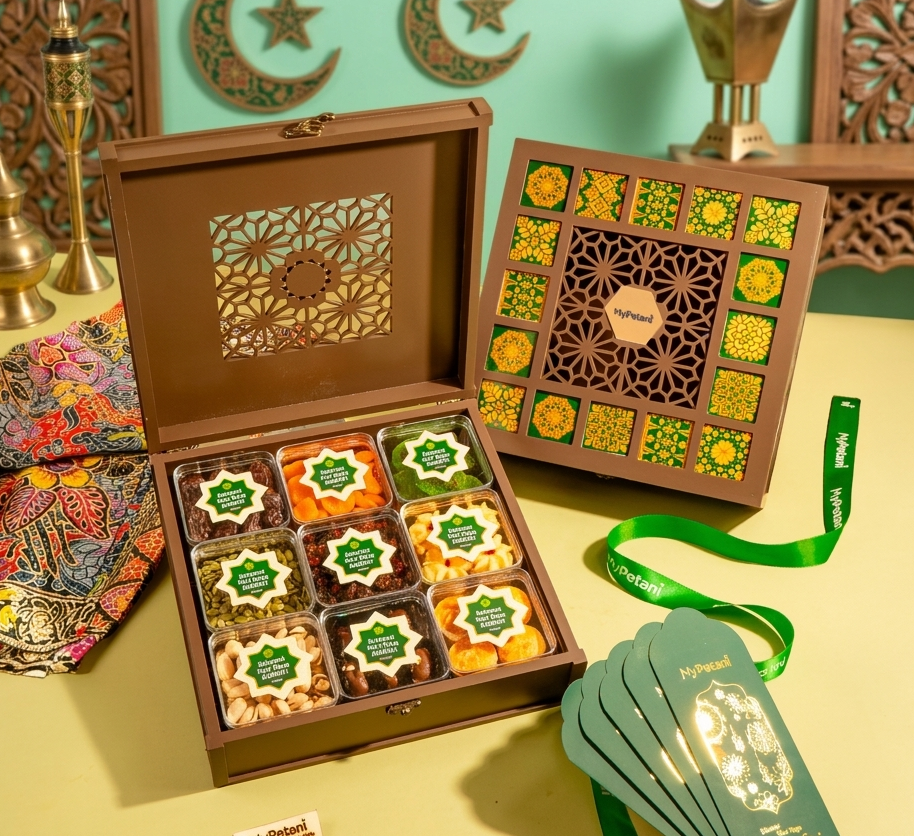 Decorative box with assorted treats, green ribbon, and cards on a yellow surface with decorative background.